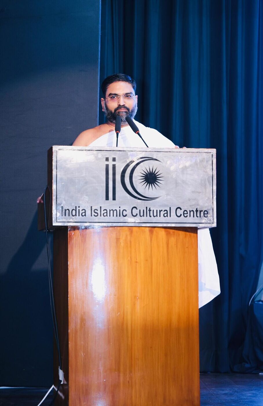 Maharaj Ji addressing the India Islamic Cultural Centre — Jain monk speaking from IICC keynote podium